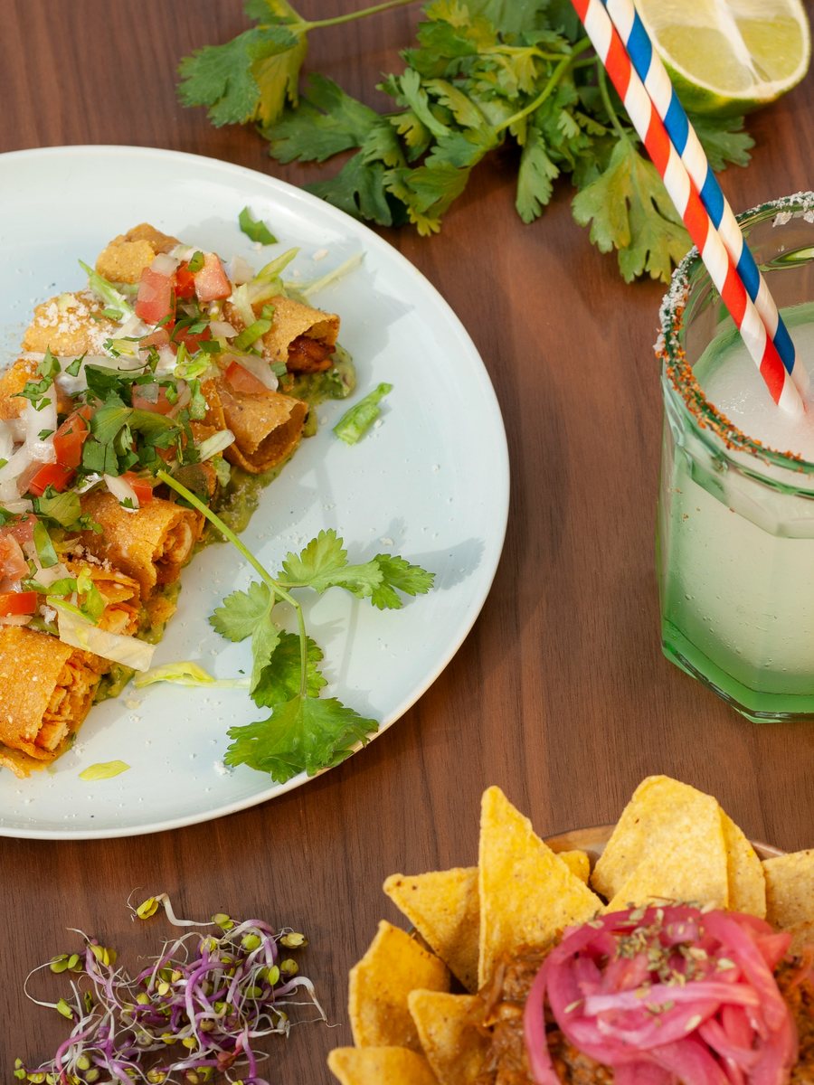 Tacos dorados topped with pico de gallo and queso